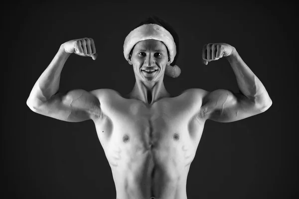 Présent pour Noël. Les courses de Noël. Fête du Nouvel An. Père Noël, mec. Homme musclé sexy en chapeau de Père Noël. Joyeuses vacances d'hiver. Rouge. Un homme puissant. Capturer un moment heureux — Photo