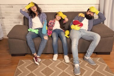 Bütün gün meslek yorucu temizlik. Yorgun ebeveyn ve çocuk. Temizlik gün yorucu. Aile anne baba ve temizlik malzemeleri ile kızı Kanepeye otur. Aile Bakımı temizlik hakkında. Temizlik bitirmek
