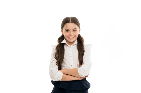 Una scolaretta ridacchiante. Adorabile scolaretta con sorriso felice che tiene le braccia incrociate. Una scolaretta carina in uniforme scolastica. Studentessa carina con lunghi capelli castani e look affascinante — Foto Stock