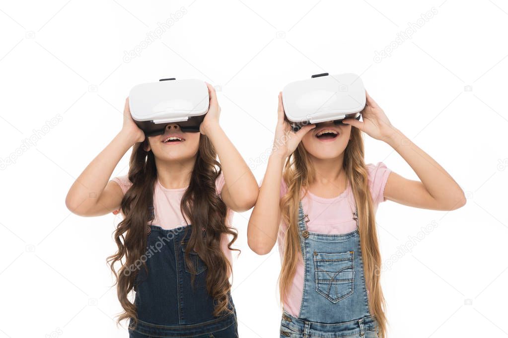 The next generation of virtual reality. Little girls wearing virtual reality headsets. Small children using virtual reality devices. Virtual reality simulation provides a truly interactive experience
