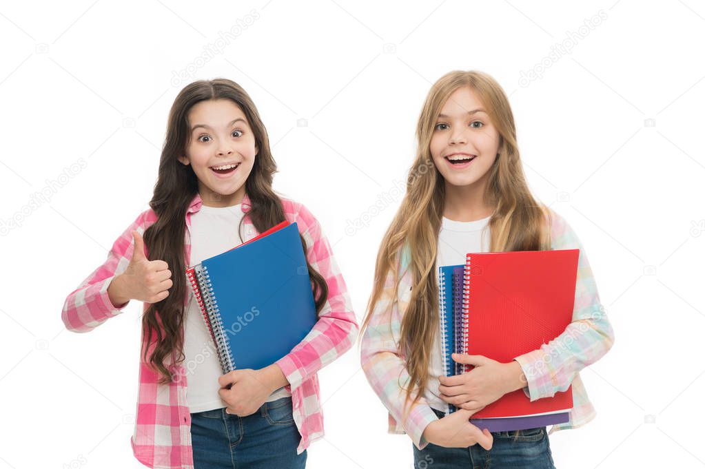 Recommending the books. Small girls giving thumbs up for school activity books. Little children enjoy writing in their note books. Exercise books taking children through the school term comfortably