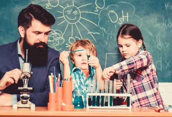 Öğretmen ve öğrenciler sınıfta test tüpleri. Çocuklar bilim gibi kulüp alanında büyüyebilir. Maddelerin özelliklerini birlikte keşfedin ve keşfedin. Kimya temalı kulüp. Okul kulübü eğitimi