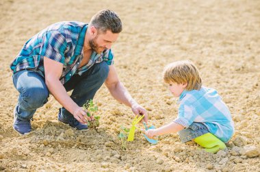 küçük çocuk çocuk tarım baba yardım. zengin doğal toprak. Eko çiftlik. baba ve oğul toprağa çiçek ekiyor. yeni bir hayat. toprak gübreleri. mutlu dünya günü. Aile ağacı. dünya günü. Yerde oturmak