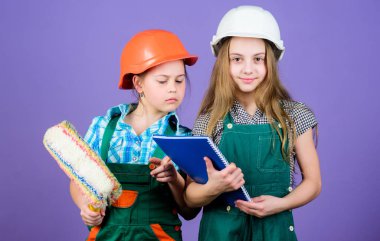 Tablet ve rulo ile kask küçük çocuklar. küçük kızlar atölyede birlikte tamir. okul projesi. İşçi bayramı. 1 mayıs. Foreman müfettişi. Onarım. Her şeyinizi onarmaya hazır