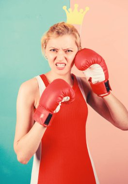 VIP salonu. Savaşçı kraliçe. Kadın boks eldiveni ve prensesin taç sembolü. Sporun kraliçesi. Boks sporunda en iyi ol. Kraliçe tacı takan dişi sarışın boks eldiveni giyiyor. Başarı için savaş