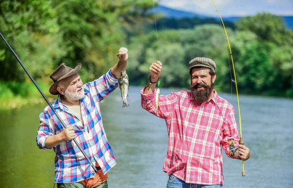 Οικογενειακή ώρα. Ψαράς με καλάμι ψαρέματος. Δραστηριότητα και χόμπι. Αλιευτικό ποτάμι γλυκού νερού στη λίμνη. Οι άνδρες με γένια πιάνουν ψάρια. Ώριμος άνθρωπος με φίλο ψάρεμα. Καλοκαιρινές διακοπές. Χαρούμενα χαρούμενα άτομα — Φωτογραφία Αρχείου