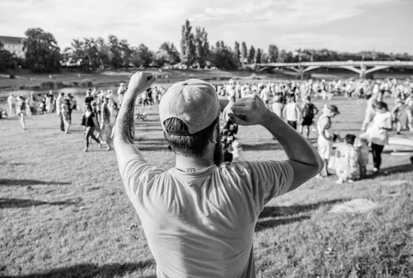 Kutlama nedenleri olması. Sakallı adam kutlama gününde kazanan jest yapıyor, geri görünümü. Hipster yaz manzara tatil kutlama zevk. Kutlamaya hoş geldiniz