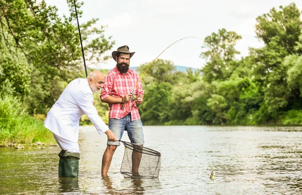 Selecção de empregos. passatempo de homem de negócios. pesca da reforma. pescadores felizes. Bom lucro. amigos homens com vara de pesca e rede. Voar aventuras de pesca. aposentado pai e maduro barbudo filho — Fotografia de Stock