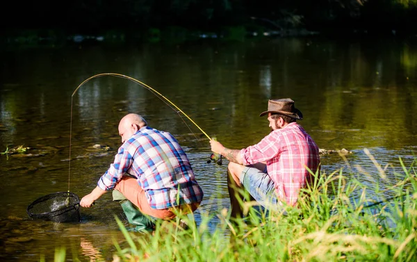 Περνάμε χρόνο μαζί. το χόμπι των ανθρώπων να πετούν ψάρια. για την αλιεία γήρατος. ευτυχείς ψαράδες φιλία. μεγάλο παιχνίδι ψαρέματος. χαλαρώσουν στη φύση. συνταξιούχος πατέρας και ώριμο μούσι γιο. Δύο άνδρες φίλοι που ψαρεύουν μαζί — Φωτογραφία Αρχείου