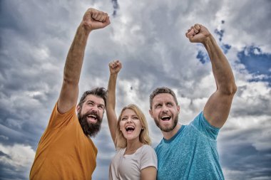 Evet yapabiliriz. Kadın ve erkek kendine güvenen başarılı gökyüzü arka plan bak. Tutarlı ekip davranışlarını. Başarı kutlamak. Ohesive takım oluşturmak için yollar. Üçlü stand güvenle yükseltilmiş yumrukları ile mutlu