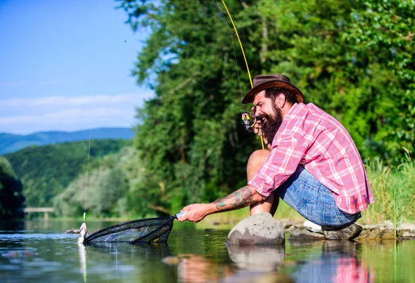 Hobby del pesce della mosca. Attività estive. pescatore di successo in acqua di lago. pesca d'altura. rilassarsi sulla natura. uomo barbuto maturo con pesce su asta. pesca hipster con cucchiaio-esca. E 'così grande. — Foto Stock