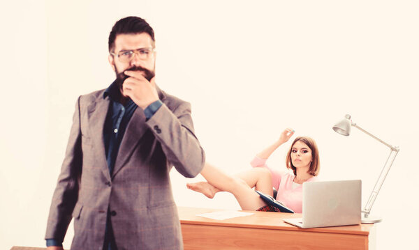 Умело и профессионально. Деловая и профессиональная женщина, работающая на рабочем месте с бородатым мужчиной на переднем плане. Сексуальный тренер, готовящийся к профессиональной подготовке в офисе. Профессиональный персонал
