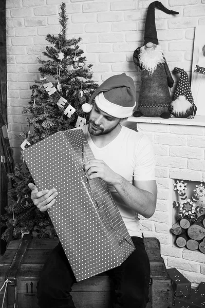 Online het winkelen van Kerstmis. Nieuwjaar tafereel met boom en geschenken. levering Kerstcadeaus. man in KERSTMUTS houden kerstcadeau. Gelukkig santa man. De ochtend voor Xmas. Kerstmis fun. — Stockfoto