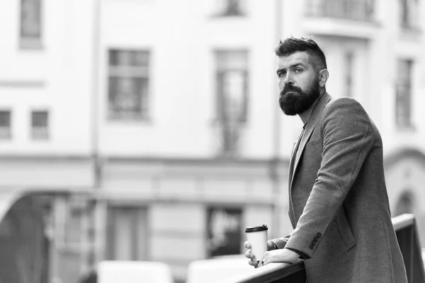 Relax and recharge. Man bearded hipster drink coffee paper cup. One more sip of coffee. City lifestyle. Businessman well groomed appearance enjoy coffee break out of business center urban background — Stock Photo, Image