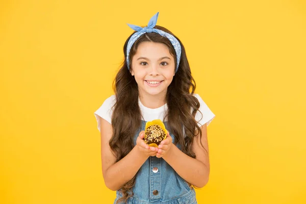 Trata a alguien con dulces. Deliciosa magdalena. Panecillo casero. Concepto de pastelería de panadería. Niña, sostén el panecillo. Receta sin gluten. Deliciosa magdalena. Niño pequeño con muffin sobre fondo amarillo —  Fotos de Stock