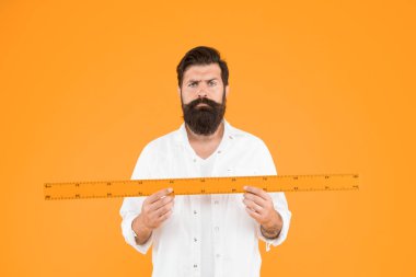 Okulda geometri öğretiyor. Turuncu arka planda ölçüm aleti tutan okul öğretmeni. Sakallı adam okul dersi için cetvel hazırlıyor. Okula tekrar hoş geldiniz