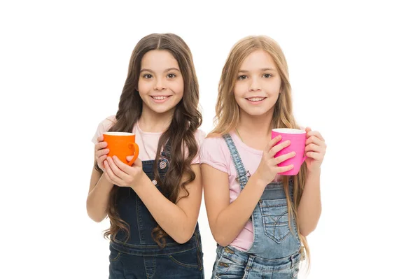 Beber leche para una buena salud. Lindos niños tomando un té con leche. Niños pequeños sosteniendo tazas con bebidas con leche tibia. Niñas disfrutando de leche caliente —  Fotos de Stock