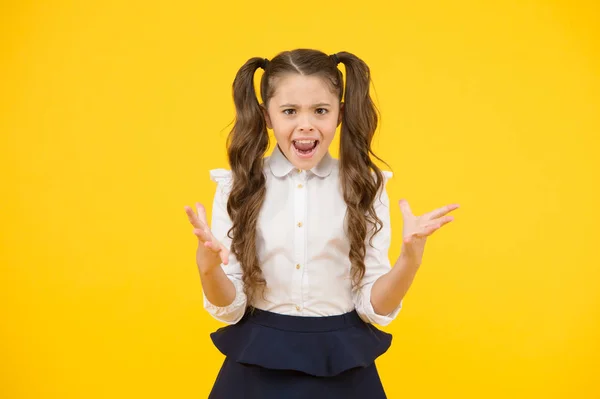 Opnieuw mislukt. Woedend schoolmeisje. Kleine schoolmeisje gebaren haar vuisten met woede op gele achtergrond. Klein schoolmeisje schreeuwen van stress of falen. Schoolmeisje heeft problemen op school — Stockfoto