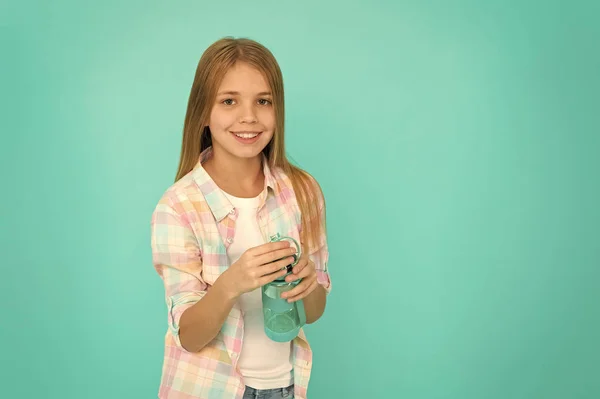 Pediatrische stoornissen van de waterbalans. Meisje geeft over gezondheid en water evenwicht. Kind houdt fles blauwe achtergrond. Kind meisje lang haar heeft waterfles. Water balans concept. Gezond en gehydrateerd — Stockfoto