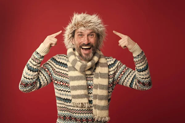 Usando algunos accesorios de invierno clave. Hombre barbudo con suéter y bufanda apuntando al sombrero. Un conjunto de invierno lo protege del frío. Modelo de moda madura en estilo de clima frío. Armario de invierno para hombre — Foto de Stock