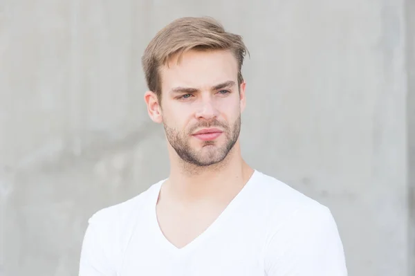 Knappe man ongeschoren gezicht stijlvolle kapsel. Knappe blanke man grijze achtergrond. Bearded Guy casual stijl close-up. Mannelijke schoonheidsnormen. Ideale eigenschappen die de mens fysiek aantrekkelijk maken — Stockfoto