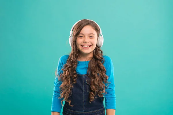 Toca el momento. Lindo chico escuchando música en auriculares estéreo. Adorable usuario de auriculares sobre fondo azul. Niño pequeño con auriculares blancos ajustables. Niña usando auriculares inalámbricos —  Fotos de Stock