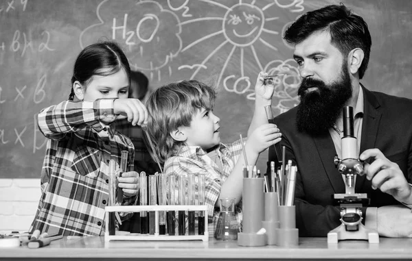 Äldre barn hjälpa yngre. School Club Education. Lärare och elever provrör i klassrummet. Kemi tema klubb. Upptäck och utforska egenskaper hos ämnen tillsammans. Intresserar och ämne klubban — Stockfoto