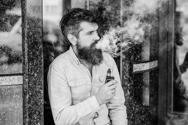 Concepto de hábitos. hombre fumando cigarrillo electrónico. hipster hombre mantenga el dispositivo de vapeo. Hipster maduro con barba. Seguridad y adicción a la salud. inhalando vapor. Barbudo brutal macho fumar cigarrillo electrónico — Foto de Stock