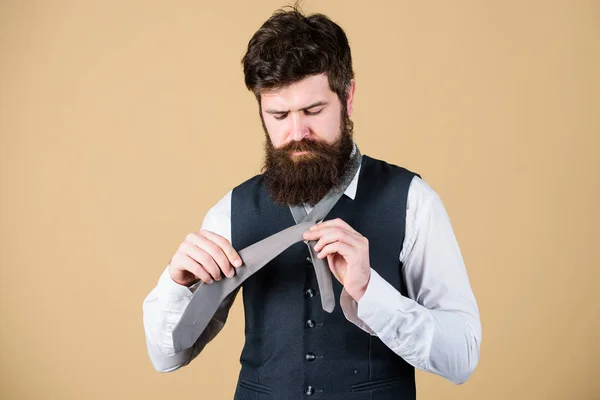 Start with your collar up and the tie around your neck. How to tie simple knot. Man bearded hipster try to make knot. Different ways of tying necktie knots. Art of manliness. How to tie necktie