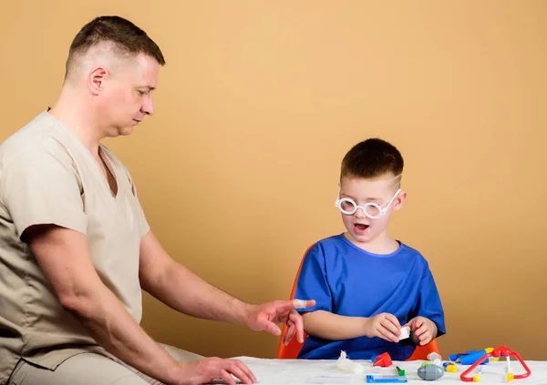 medicine and health. happy child with father with stethoscope. family doctor. trust and values. father and son in medical uniform. small boy with dad in hospital. medicine concept. medicine game