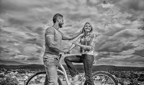 Man with beard and shy blonde girl on first date. Couple just meet to hang out together. Woman feels shy in company with attractive macho. asual acquaintance concept. Rolling romance or bike date