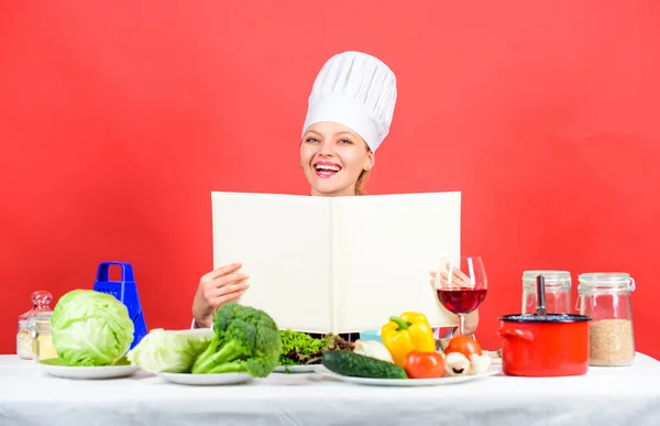 Woman reading cook book in kitchen. Girl cook at kitchen table ingredients. Tips and advice. Preparing food. Delicious and gourmet. Cooking food as hobby. Cook looking for cooking recipe in cookbook