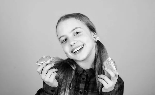 Ela é tão doce que faz a comida saber bem. Menina pequena sorrindo com comida de sobremesa recém-assada. Criança feliz segurando comida caseira em copos. Quantos desses doces você gosta de comer? — Fotografia de Stock