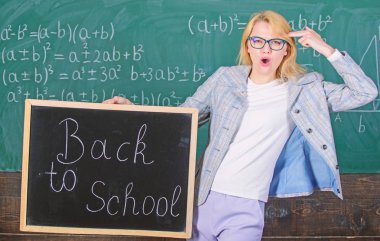 Kadın öğretmen blackboard kara tahta arka plan üzerinde okul yazıt için geri tutar. Özel indirim indirim Satılık okul sezonu. Okula geri özel teklif. Sansasyonel eğitim promosyonu için geçerli olan