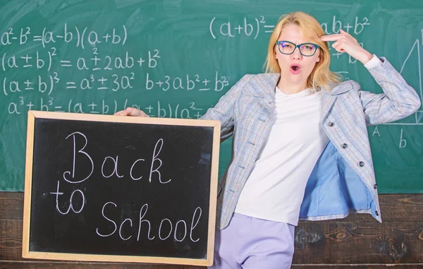 Kadın öğretmen blackboard kara tahta arka plan üzerinde okul yazıt için geri tutar. Özel indirim indirim Satılık okul sezonu. Okula geri özel teklif. Sansasyonel eğitim promosyonu için geçerli olan