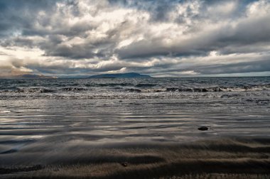 reykjavik, İzlanda'arka plan kıyısında dağ ile dramatik deniz manzarası. deniz ve bulutlu gökyüzü manzarası. Yolculuk tutkusu veya seyahat ve macera. Reykjavik güzel doğa. İzlanda manzara.