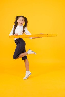 Ders vermek için acelesi var. Enerjik okul çocuğu ders çizmek için uzun cetvel tutan. Matematik ve geometri dersine hazırlanan küçük kız. Okul dersinde ölçme aleti kullanma