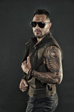 Güçlü silah dövme sakallı adam. Tıraşsız yüzündeki sakallı dövme modeli. Pazı ve triceps dövmeli adam. Moda maço trendy güneş gözlüğü. Moda stil ve trend, vintage filtre
