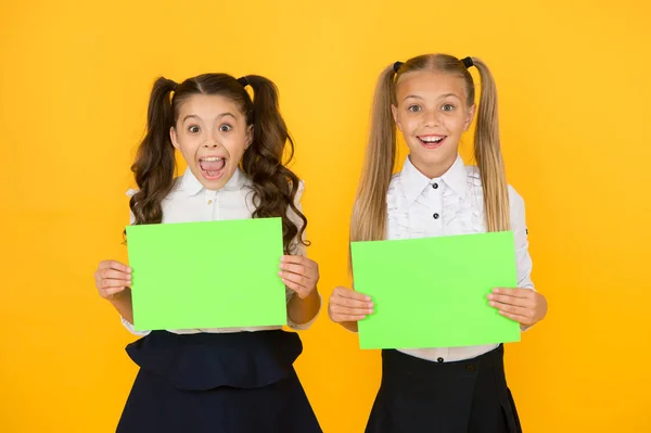 Las colegialas muestran póster. Espacio de copia de póster social. La socialización implica cómo los niños se llevan bien entre sí. Socialización escolar. Cartel de uniformes escolares para niñas. Regreso al concepto escolar — Foto de Stock