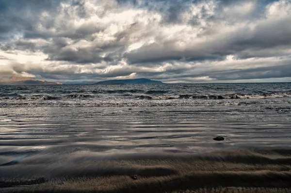 reykjavik, İzlanda'arka plan kıyısında dağ ile dramatik deniz manzarası. deniz ve bulutlu gökyüzü manzarası. Yolculuk tutkusu veya seyahat ve macera. Reykjavik güzel doğa. İzlanda manzara.