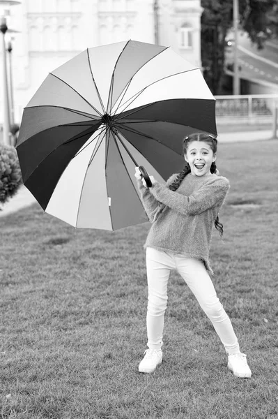 Niña de pelo largo caminando parque con paraguas. Manténgase positivo y optimista. Colorido accesorio influencia positiva. Paraguas brillante. Bajo un gran paraguas. Accesorio colorido para el humor alegre — Foto de Stock
