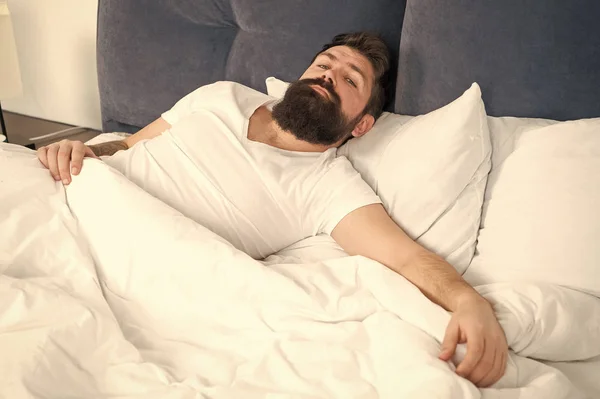 Sleep disorders concept. Man bearded hipster having problems with sleep. Guy lying in bed try to relax and fall asleep. Relaxation techniques. Violations of sleep and wakefulness. What a long night