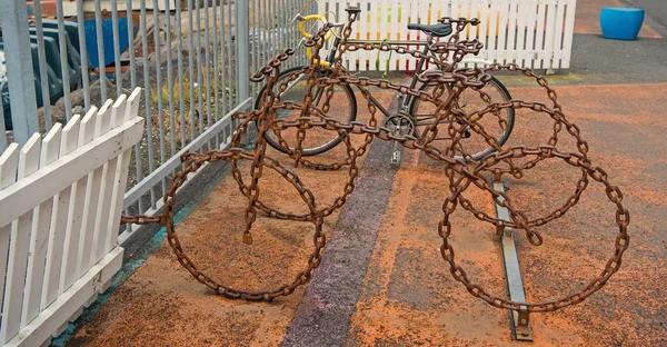 Bicycle parking as art object. Cycling culture and infrastructure. Bicycle parking made out of brutal metal chain. Leave your bike here. Bicycle transportation system. Urban cycling infrastructure