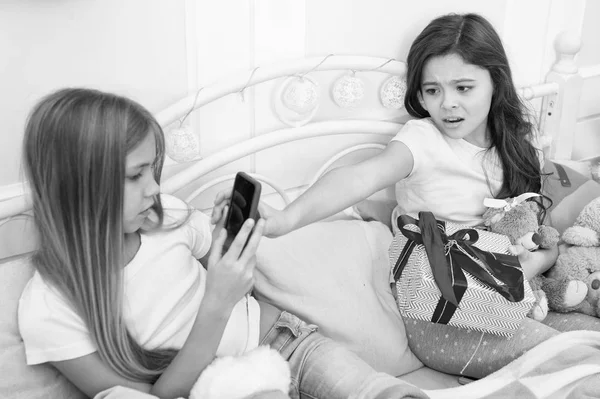 No me gusta. Las niñas pequeñas usan el teléfono en la cama. Tomar fotos de Navidad y Año Nuevo con smartphone. Niños pequeños felices con teléfono móvil. Feliz Navidad y Feliz Año Nuevo saludos —  Fotos de Stock