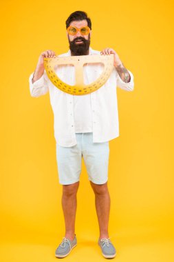 Derse hazır olmak. Sakallı adam matematik dersi için protractor tutarak. Matematik öğretmeni veya geometri dersine hazırlanan öğrenci. Hipster okul dersinde ölçüm aleti kullanarak