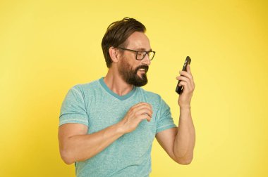 Hippi neşeli akıllı telefon kullanımı. Modern akıllı telefonun mutlu kullanıcısı. Modern akıllı telefonla iletişimde kal. Çevrimiçi topluluğa katıl. Kullanıcı dostu kavram. Adam cep telefonu fırsatları konusunda heyecanlı.