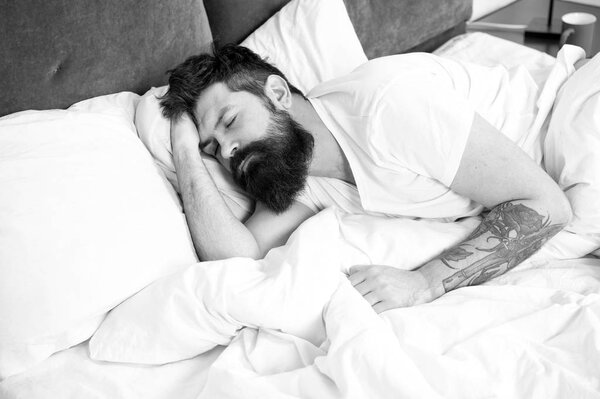 Мне нужно отдохнуть. Концепция расстройств сна. У бородатого хипстера проблемы со сном. Парень лежит в постели, пытается расслабиться и заснуть. Методы релаксации. Нарушения сна и бодрствования
