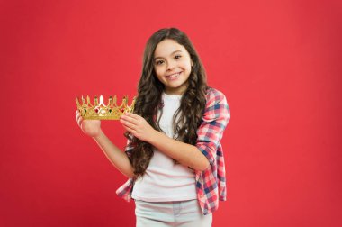 Çok zengin bir ödül. Küçük kız kırmızı arka planda taç ödülü tutuyor. Başarı için değerli ödül ile Successfil küçük kazanan. Değerli ödül ve ödül kazanma