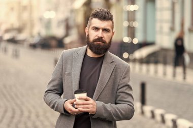 Adam hipster içki kahve kağıt bardak sakallı. İyi bakımlı işadamı kahve arası açık havada kentsel arka plan tadını çıkarın. Düşünceli ama rahat. Yürümek ve taze sıcak kahve keyfini çıkarın. Gevşeme söz konusu