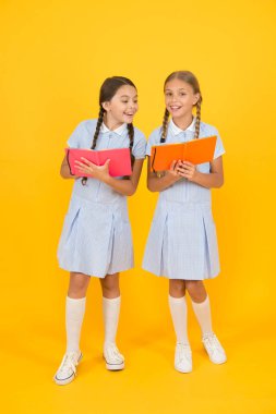 Okul kütüphanesi. Okullar için eğitim kitapları. Kitap okuyorum. Evde eğitim konsepti. Okuryazarlık kulübü. Sarı arka plan üzerine kitaplar tutan sevimli çocuklar. Ansiklopedi veya çocuk kitapları ile küçük kızlar